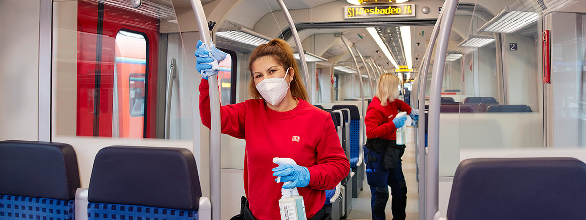 Foto von einer Frau, die in Schutzkleidung eine S-Bahn reinigt
